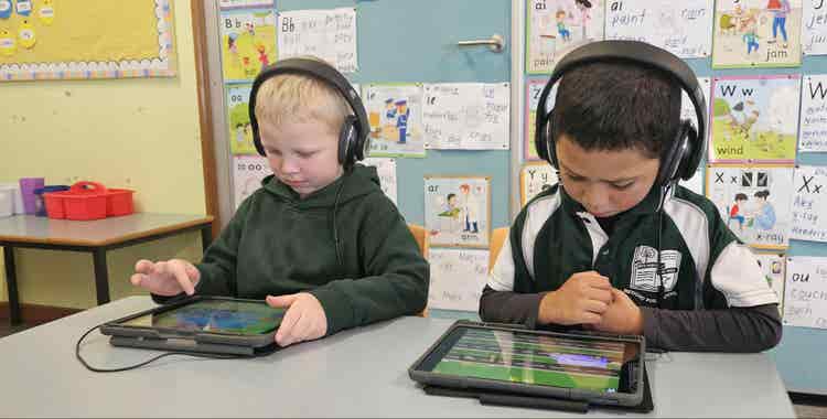 Two kindergarten students working with iPads